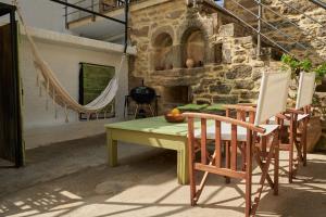 a table and two chairs and a hammock in a patio at Studio Batilas in Kaláthenai