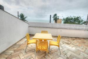 einen Tisch und Stühle auf einer Terrasse mit Meerblick in der Unterkunft Yatch Village Flat in Natal