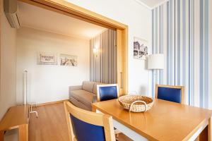 a dining room with a table and chairs and a couch at BeGuest Olhão Ria Formosa View in Olhão