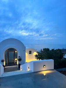 a house with a view of the ocean at night at LF Suites & Villas in Imerovigli