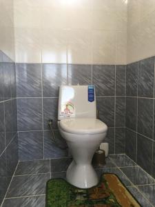 a bathroom with a toilet with a picture on the tank at Эдем in Cholpon-Ata