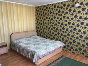 - une chambre avec un lit et un papier peint floral dans l'établissement Эдем, à Cholpon-Ata