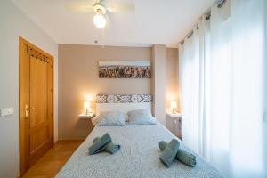 - une chambre avec un grand lit et des oreillers bleus dans l'établissement Apartamento Cantarero, à Nerja