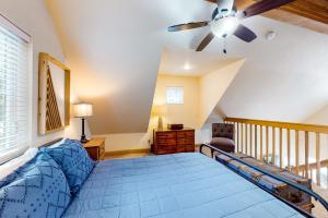 een slaapkamer met een blauw bed en een plafondventilator bij Dover Hideaway in Dover