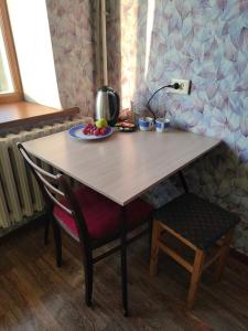 a table and chair with a plate of fruit on it at Glinki 33 Apartments in Semey