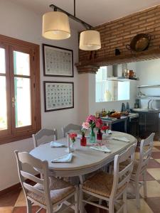 a kitchen with a table and chairs with flowers on it at Casa Rural Humberto con 3 dormitorios in Málaga