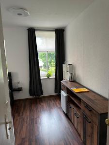 Zimmer mit einem Schreibtisch und einem Fenster in einem Zimmer in der Unterkunft Pension Zur Wartburg in Olbernhau