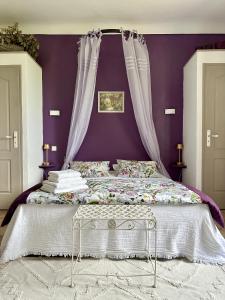 - une chambre avec un lit aux murs violets dans l'établissement Mas de la Sacristière, à Jonquerettes