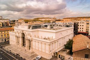 un grand bâtiment blanc dans une ville dans l'établissement Monti 66 Hotel, à Rome