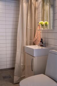 a bathroom with a sink and a shower curtain at 1700-talshus i två plan med egen innergård i Visby innerstad in Visby