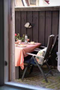 a table with two chairs and a pink table cloth at 1700-talshus i två plan med egen innergård i Visby innerstad in Visby
