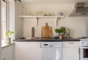 a kitchen with white cabinets and a sink at 1700-talshus i två plan med egen innergård i Visby innerstad in Visby