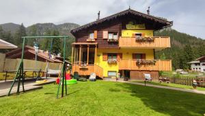 a house with a playground in front of it at Villa L'Aida in Canazei