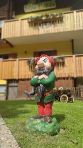 a statue in the grass in front of a building at Villa L'Aida in Canazei