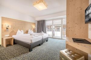 um quarto de hotel com duas camas e uma televisão em Harakiri lodgings und ApresSki em Mayrhofen