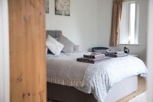 a bedroom with a bed with towels on it at Cygnets Nest in Worstead