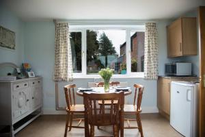 a kitchen with a table and chairs and a window at Cygnets Nest in Worstead
