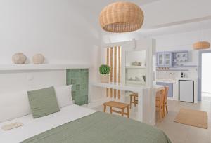 a white bedroom with a bed and a kitchen at Korali in Astypalaia Town