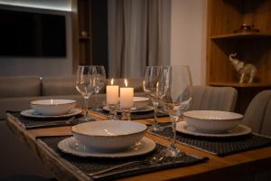a table with plates and wine glasses and candles at Aggire Zante Luxury Residence in Zakynthos Town