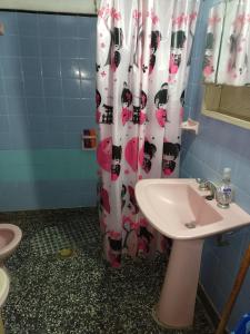 a bathroom with a shower curtain with a toilet and a sink at LA MAGA in Remedios de Escalada