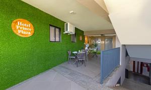 ein Restaurant mit einer grünen Wand mit einem Tisch und Stühlen in der Unterkunft Treebo Trend Prince Plaza in Ahmedabad