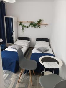 2 camas en una habitación con mesa y sillas en Domki Letniskowe i Pokoje NATALIE, en Mielno