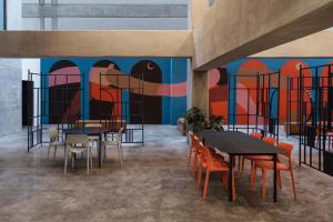 ein Esszimmer mit Tischen und Stühlen und einem Wandbild in der Unterkunft Loft In The Heart Of Americana, Have An Artsy Stay in Guadalajara