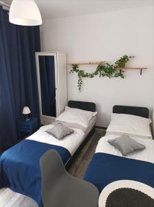 Habitación con 2 camas y silla en Domki Letniskowe i Pokoje NATALIE, en Mielno