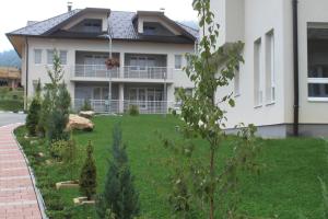 a house with a green yard in front of it at Countryside Resort Sarajevo in Hadžići