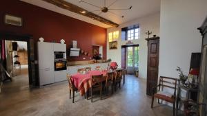 eine Küche und ein Esszimmer mit einem Tisch und einem Kühlschrank in der Unterkunft Manoir de La Garaye - Suite Parentale in Taden