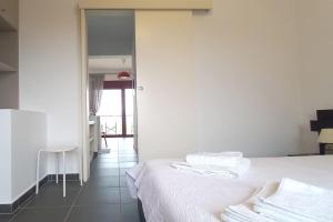 a bedroom with a bed and a table and a mirror at A balcony of Aegina by the saronic gulf in Aegina Town