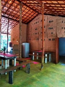 um quarto com mesas e um frigorífico num edifício em Canto do Morere em Morere