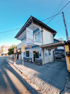 ein weißes Gebäude an der Straßenseite in der Unterkunft Pousada Água Marinha in Cabo Frio