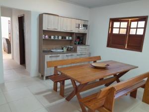jadalnia z drewnianym stołem i ławkami w obiekcie Casa de Temporada Ceu e Mar w mieście Praia do Bananal