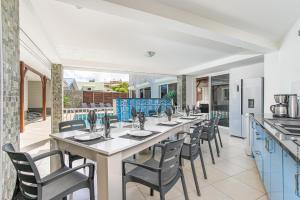 une grande salle à manger avec une grande table et des chaises dans l'établissement Villa Kaju : grande piscine et proche plage, à Sainte-Luce