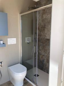 a bathroom with a toilet and a glass shower at Ristella Home in Monopoli