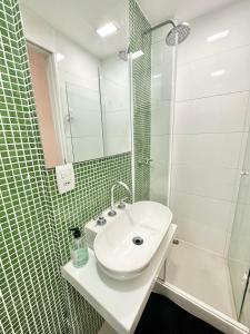 a bathroom with a sink and a glass shower at Ipanema Beach lovely apartment in Rio de Janeiro
