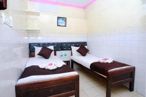 a room with two beds with towels on them at Aum Karthikeya Residency in Chennai