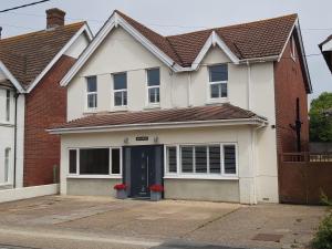 a white house with a brown roof at Bay House in Totland