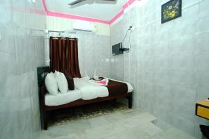 a room with a bed with white pillows on it at Aum Karthikeya Residency in Chennai