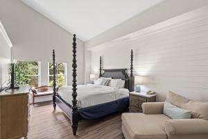 聖邁克爾斯的住宿－海濱Spa聖米歇爾港酒店，一间卧室配有四柱床和沙发