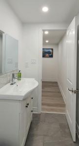 bagno bianco con lavandino e specchio di Deluxe Private Room in North York a Toronto