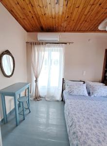 1 dormitorio con 2 camas, mesa y ventana en Giasemi traditional house, en Poros