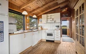 een keuken met witte kasten en een houten plafond bij Gorgeous Home In Fan With Kitchen in Fanø