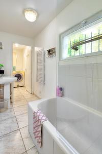 a white bathroom with a tub and a sink at Maison de charme à la campagne in Roupy