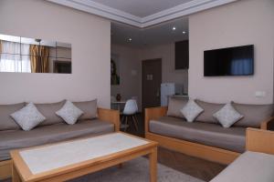 uma sala de estar com dois sofás e uma televisão em Golden Beach Appart'hotel em Agadir