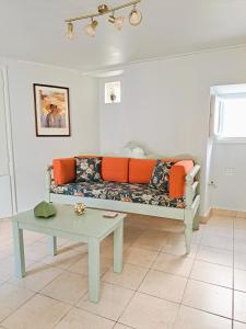 ein Wohnzimmer mit einem Sofa und einem Tisch in der Unterkunft Giasemi traditional house in Poros