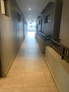 a hallway with a tile floor in a building at Zimbali Lakes Boulevard Suites Studio Apartments in Ballito