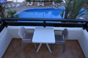 uma mesa branca e cadeiras ao lado de uma piscina em Golden Beach Appart'hotel em Agadir