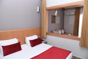 - une chambre avec un lit doté d'oreillers rouges et d'un miroir dans l'établissement Golden Beach Appart'hotel, à Agadir